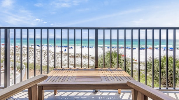 A wooden deck with a view of a beach with umbrellas and people. - Windancer 307. Gulf Front Condo, Free Beach Service, Heated Pool, Grill. (Miramar Beach)