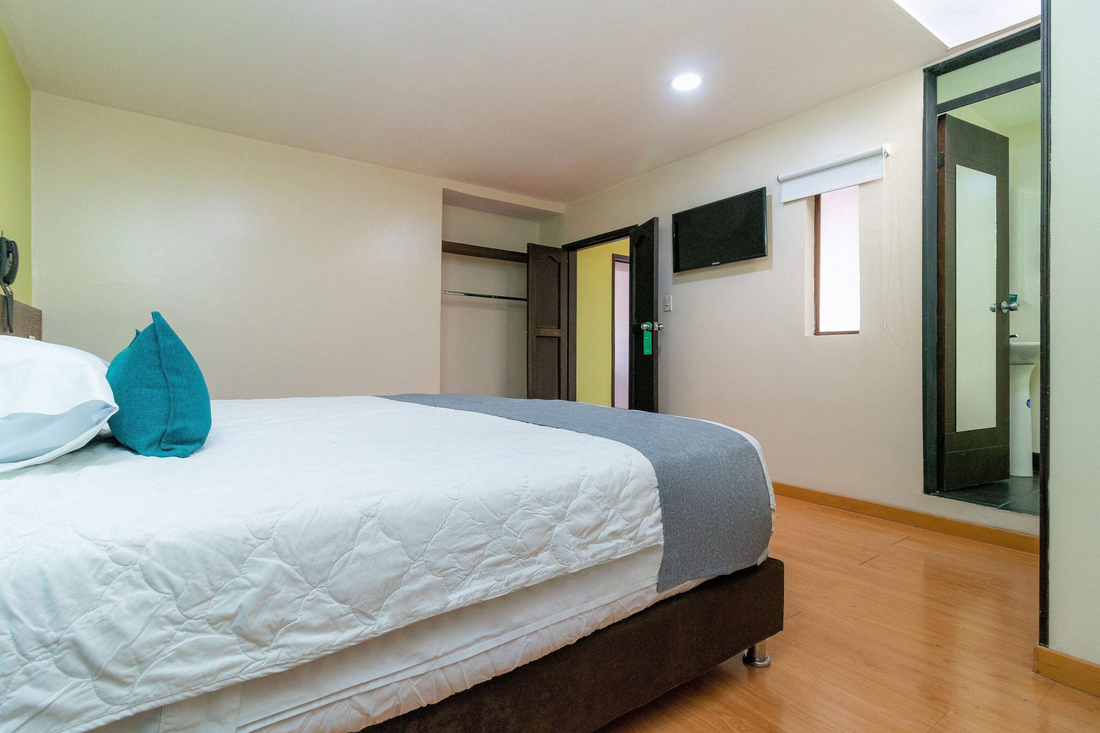 A bedroom with a bed, a wardrobe, and a mirror.