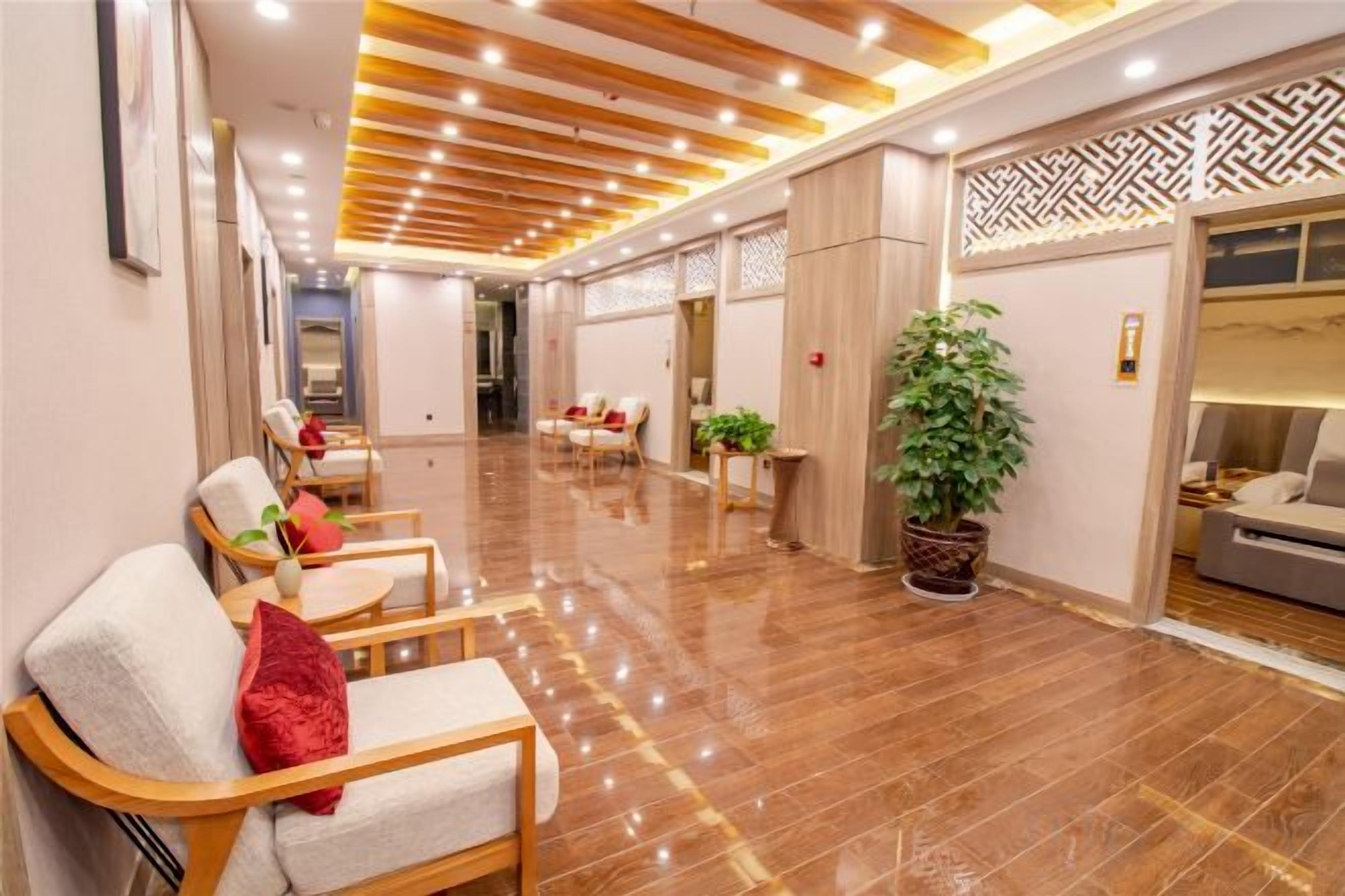 Un hall de hotel con asientos, una recepción y una planta en maceta.