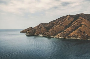 A coastal landscape with a series of rocky hills and calm sea.