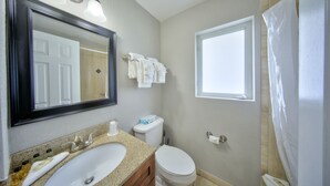 A bathroom with a sink, toilet, and a mirror. - Surf and Sand Seaside (Pompano Beach)
