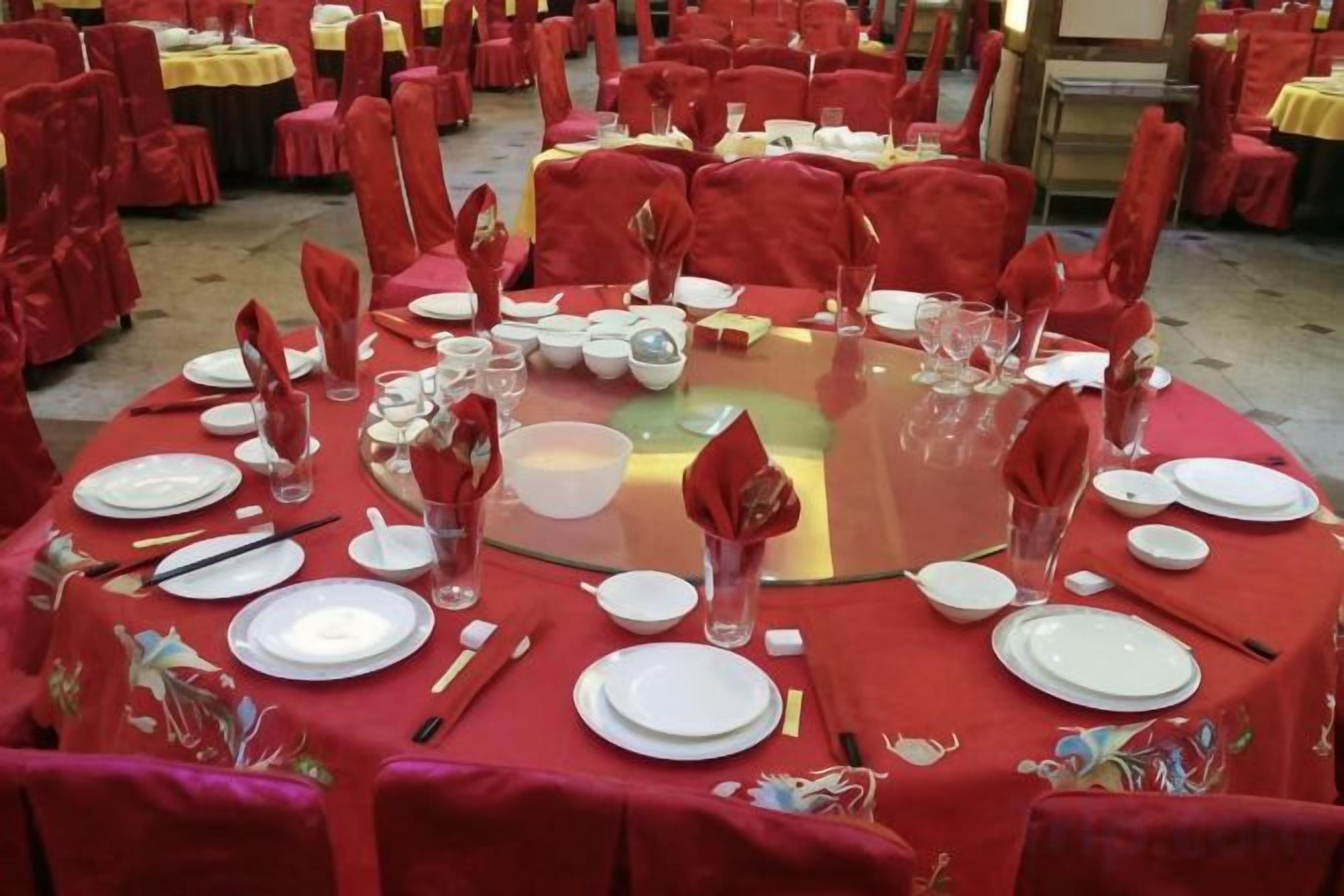 Mesa redonda dispuesta para comer, con manteles y sillas a juego.