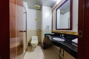 A small bathroom with a toilet, sink, and mirror. - Foshan Tenghai Hotel (Foshan)