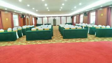 A conference room with multiple tables, a red carpet, and a patterned carpet.