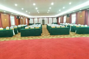 Un salón de conferencias con varias mesas, alfombra roja y un suelo con estampado.