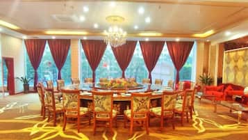 A conference room with a round table, chairs, and a chandelier.