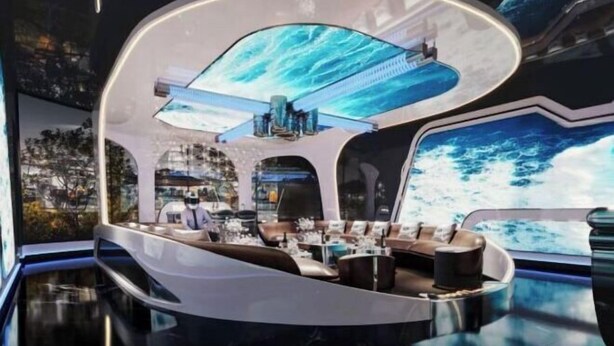 Futuristinen sisustus, jossa on kaareva istuinalue, keskeisellä paikalla oleva pöytä ja suuri panoraamanäyttö, jolla esitetään merimaisema.