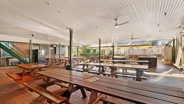 A covered outdoor dining area with picnic tables and a staircase leading to an upper level. - Central Hotel Stroud (Stroud)