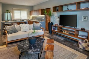 Un salon moderne avec un canapé, une table basse et un meuble pour la télévision.