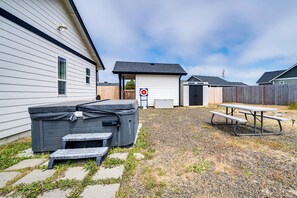 En baghave med jacuzzi, picnicbord og en målgynge.