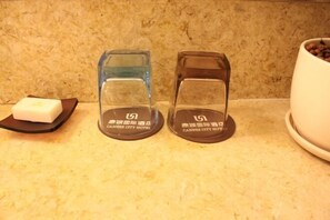 Two glass candle holders with the text "Cannes City Hotel" on a countertop.