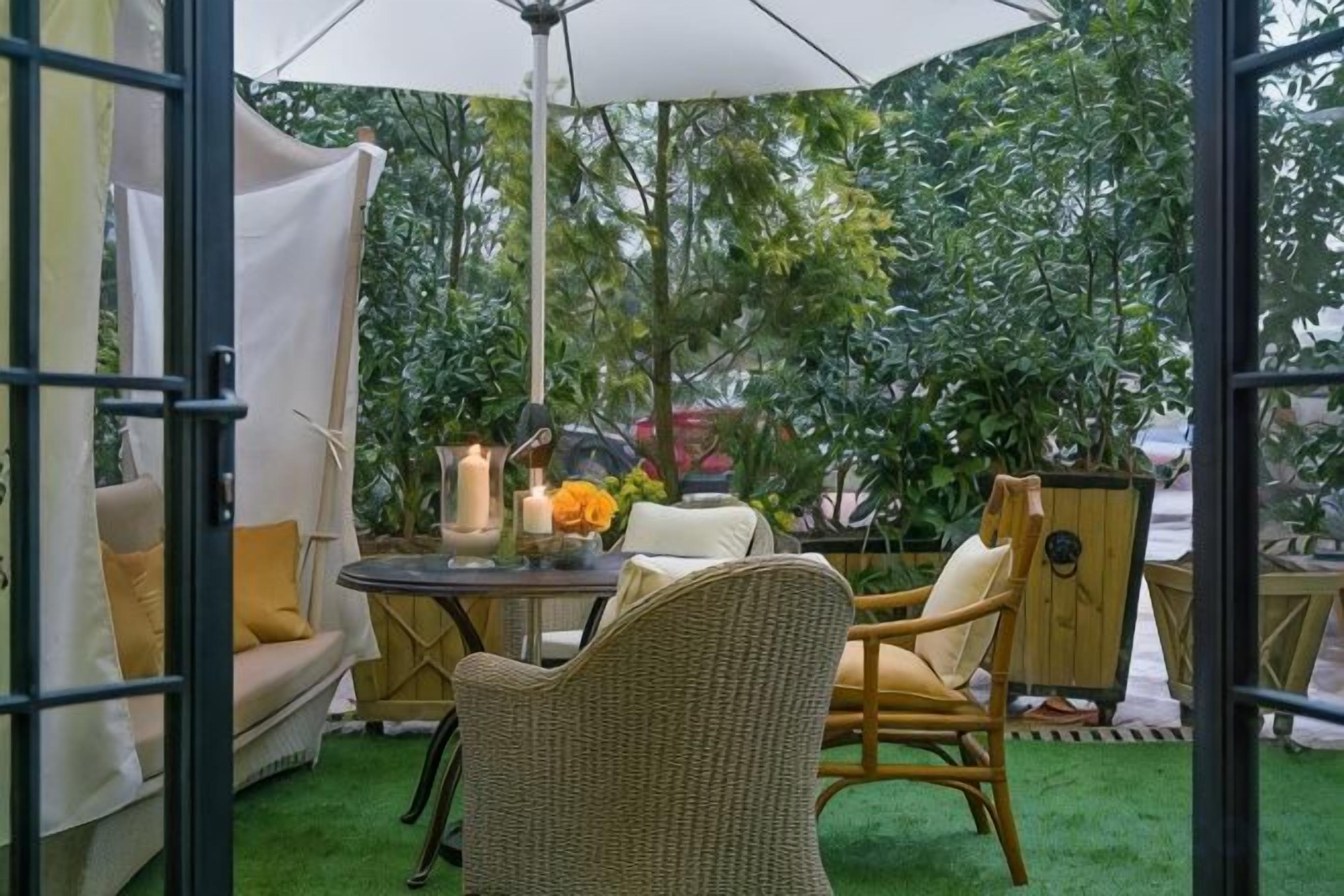 An outdoor seating area with a table, chairs, and a canopy.