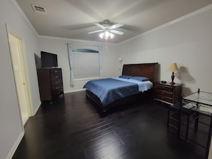 A bedroom with a bed, dresser, ceiling fan, and window with curtains. - "The Love Birds" -4 bed/ 2 bath single story in Remington Heights (San Antonio)