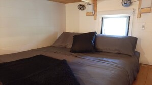 A bedroom with a bed, pillows, and a blanket.