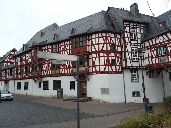 A traditional half-timbered building with a white facade and red timber framing.