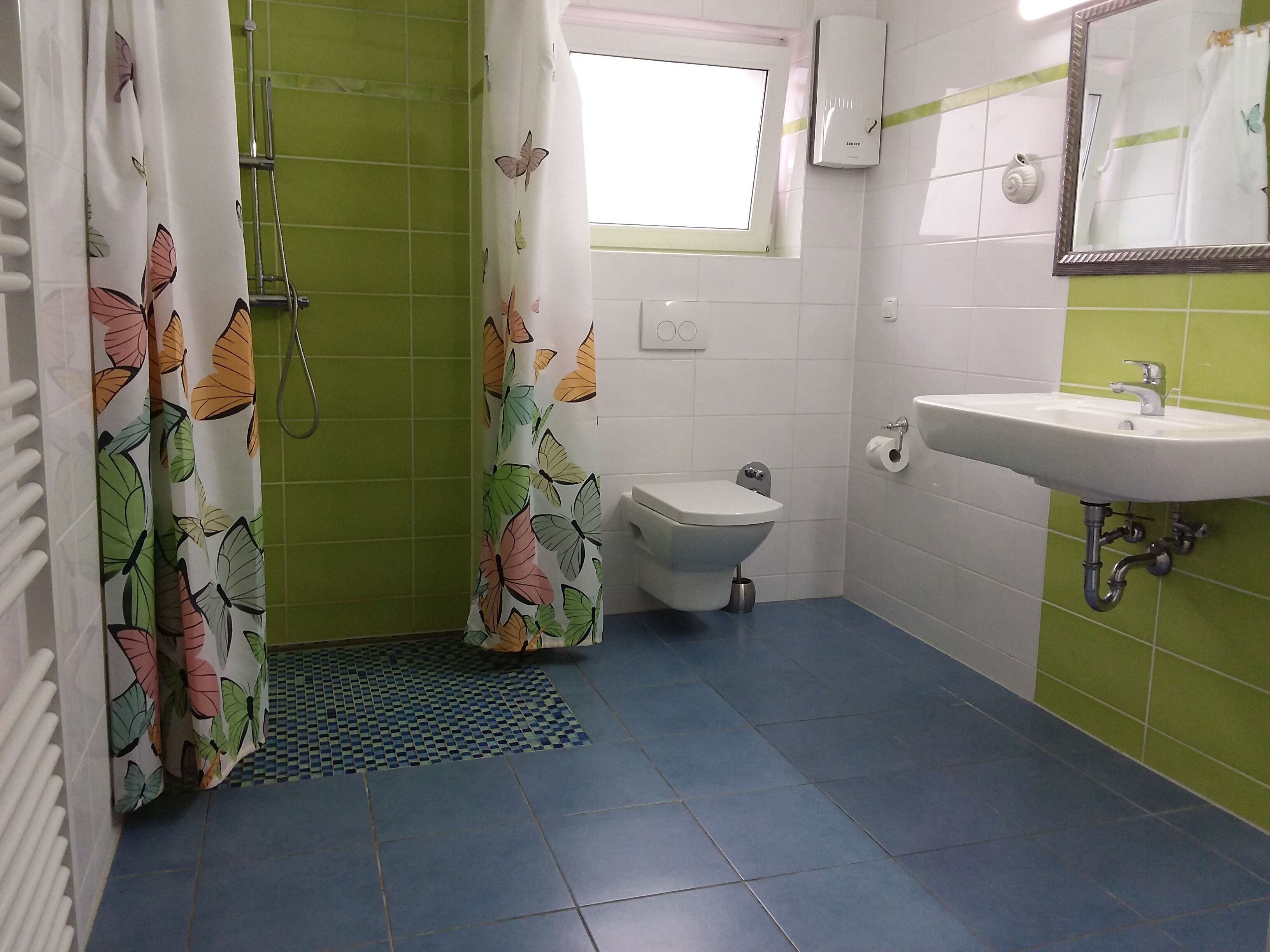Un baño con inodoro, lavamanos y zona de ducha.