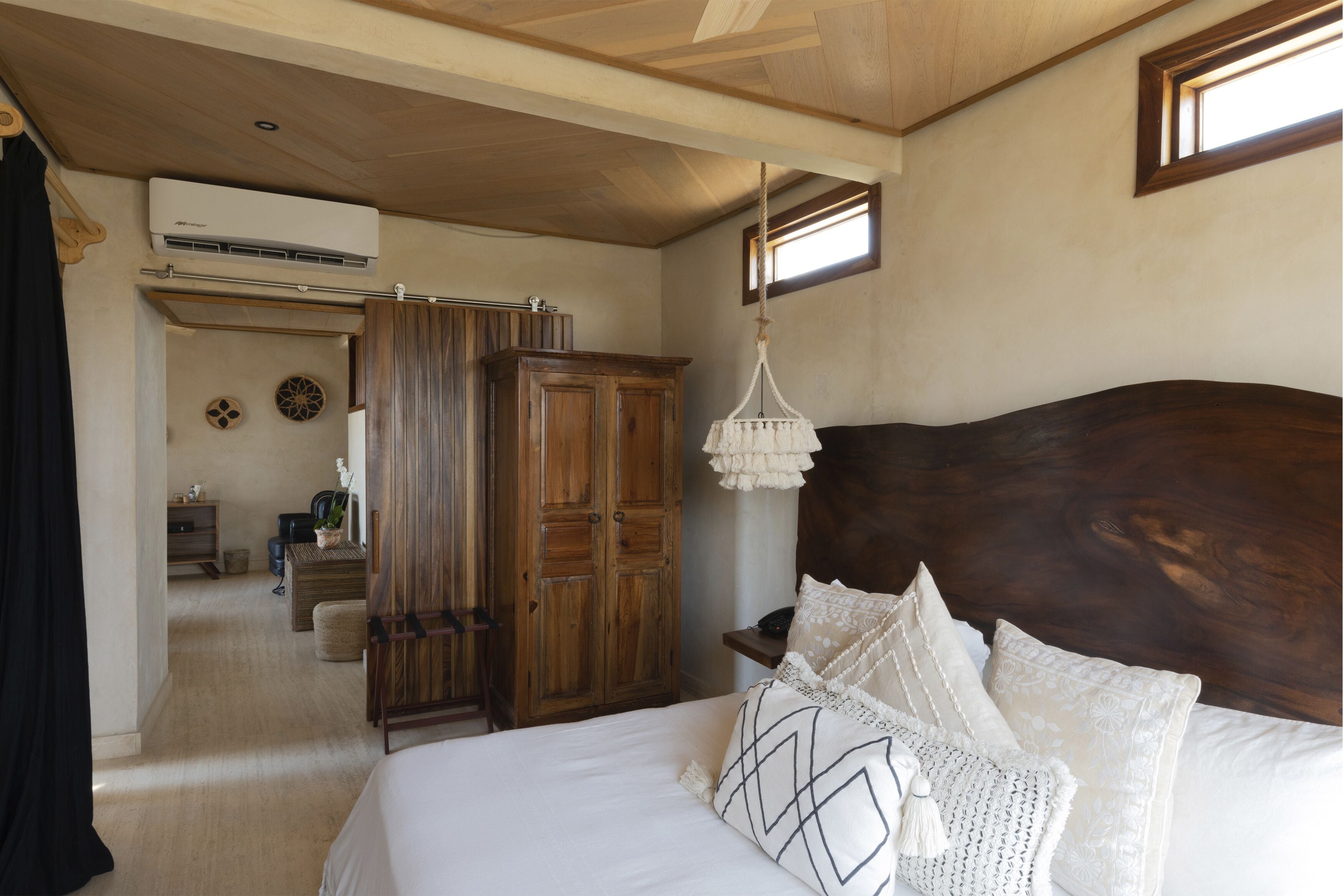 Ein Schlafzimmer mit einem großen Bett, einem Holzkopfende und einer Pendelleuchte.
