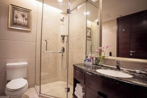 A modern bathroom with a glass-enclosed shower, a marble sink, and a dark wooden cabinet. - Jinlong Yufeng Hotel (Changde Huanlecheng High Speed Railway Station) (Changde)