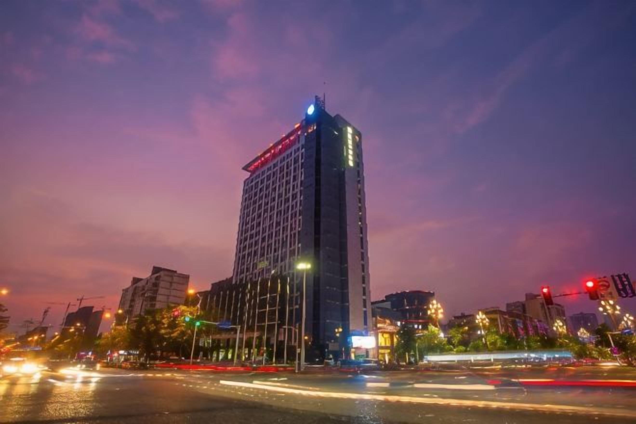 A high-rise building with a modern design, located in an urban setting with visible traffic and street lights.