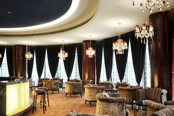 A luxurious lobby with a curved ceiling, chandeliers, plush seating, and a reception desk. - Jinlong Yufeng Hotel (Changde Huanlecheng High Speed Railway Station) (Changde)