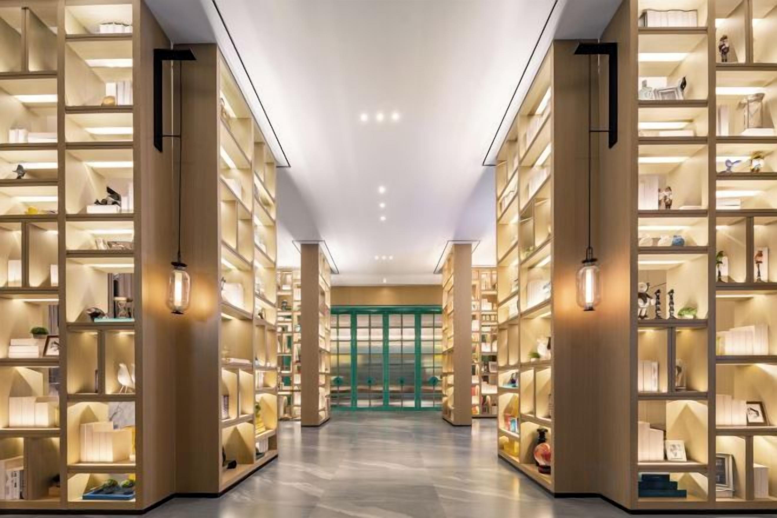 A library with bookshelves on both sides of a central walkway.