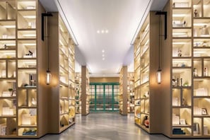 A library with bookshelves on both sides of a central walkway. - Heyue Hotel（Olympic Sports Center Store） (Jinan)