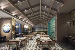 Un restaurant avec un plafond haut, de nombreuses tables et des chaises.
