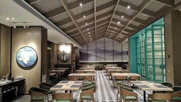 A restaurant with a high ceiling, round tables, and chairs.