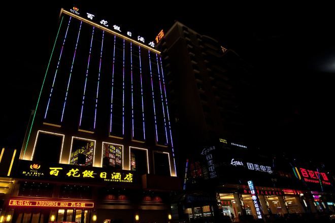 A multi-story building with illuminated vertical lines and signage.