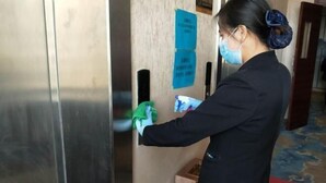 Una persona limpiando un picaporte con un paño.