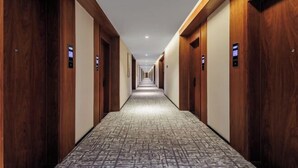A long, narrow hotel corridor with wooden doors on both sides and a patterned carpet. - Gemei Hotel (Hefei China Sound Valley Zhongke University) (Hefei)