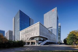 Un hôtel moderne doté d’une architecture originale, caractérisé par une façade en verre remarquable et une structure angulaire unique.