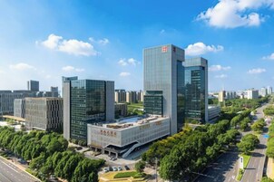 Silhueta urbana moderna com edifícios altos, céu claro e área verde bem cuidada.
