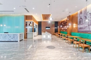 Un interno moderno con una reception, un'area salotto e un grande murale.