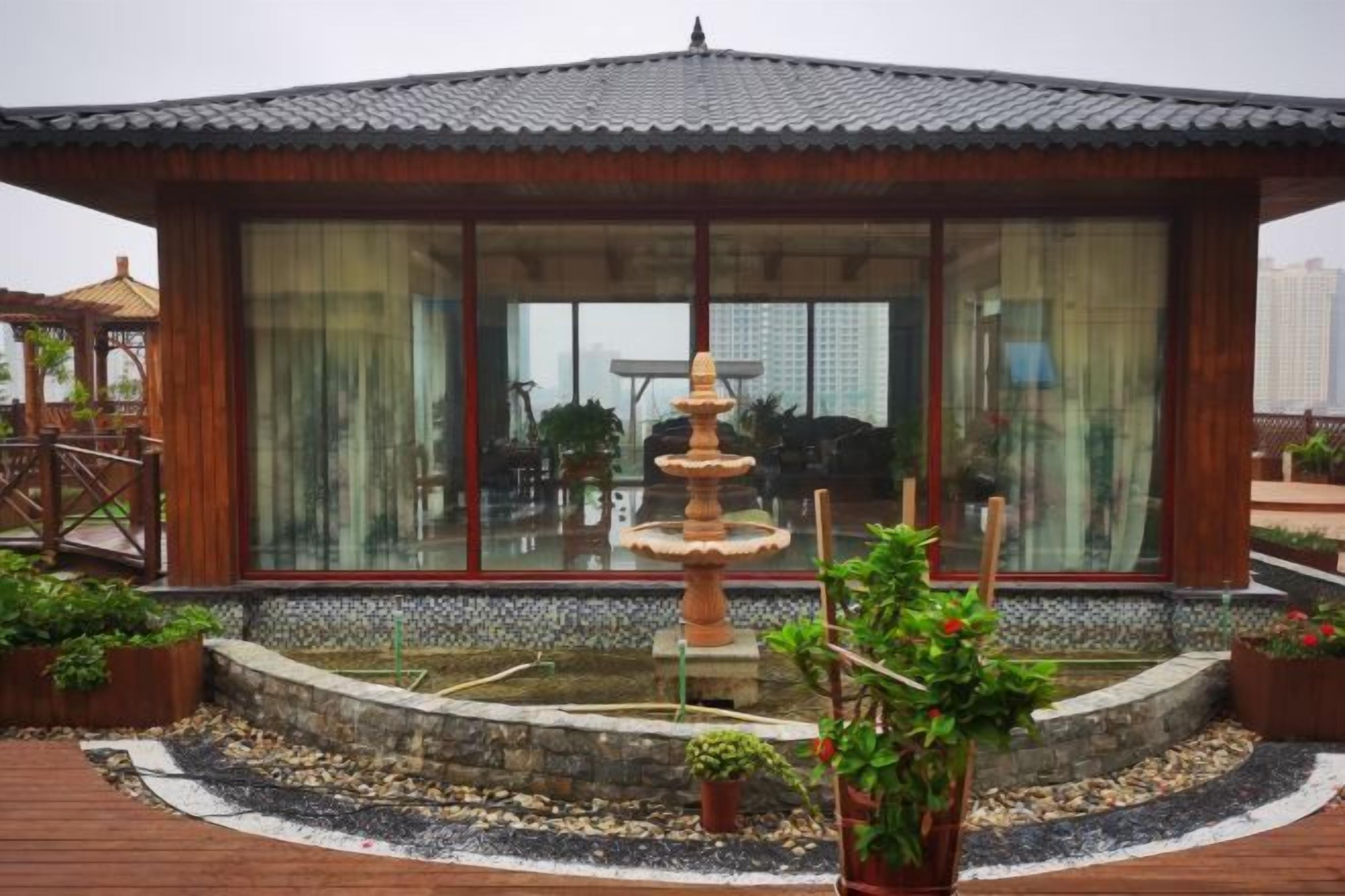 A building with a tiled roof, large windows, and a central fountain.
