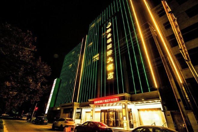 A multi-story hotel with a prominent entrance and illuminated signage.