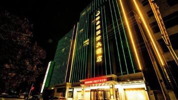 A multi-story hotel with a prominent entrance and illuminated signage.