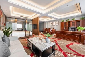 Een moderne hotelkamer met een groot bed, een bureau en een zithoek.