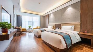 A modern hotel room with a large bed, a desk, and a chair.