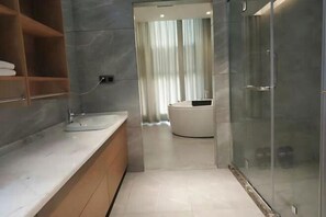 A modern bathroom with a glass-enclosed shower, a white sink, and a built-in bathtub.