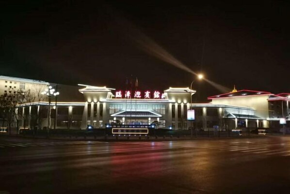 A large, modern building with a prominent entrance and illuminated signage.