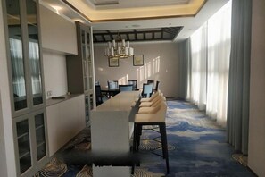 A conference room with a long table, chairs, and a chandelier. - Yingbin Hotel (Linzhang)