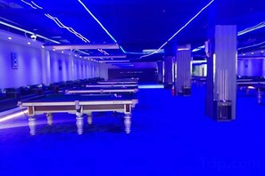A room with multiple pool tables, a dark floor, and blue ambient lighting. - Yingbin Hotel (Linzhang)