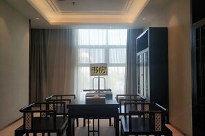 A room with a large window, a table with chairs, and a sign with Chinese characters. - Yingbin Hotel (Linzhang)