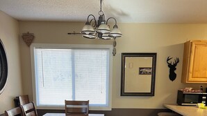 A kitchen with a dining table, chairs, a bench, a microwave, and a cabinet.