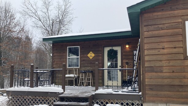 A wooden cabin with a porch, steps leading up to the door, and a sign indicating a nearby eagle crossing.