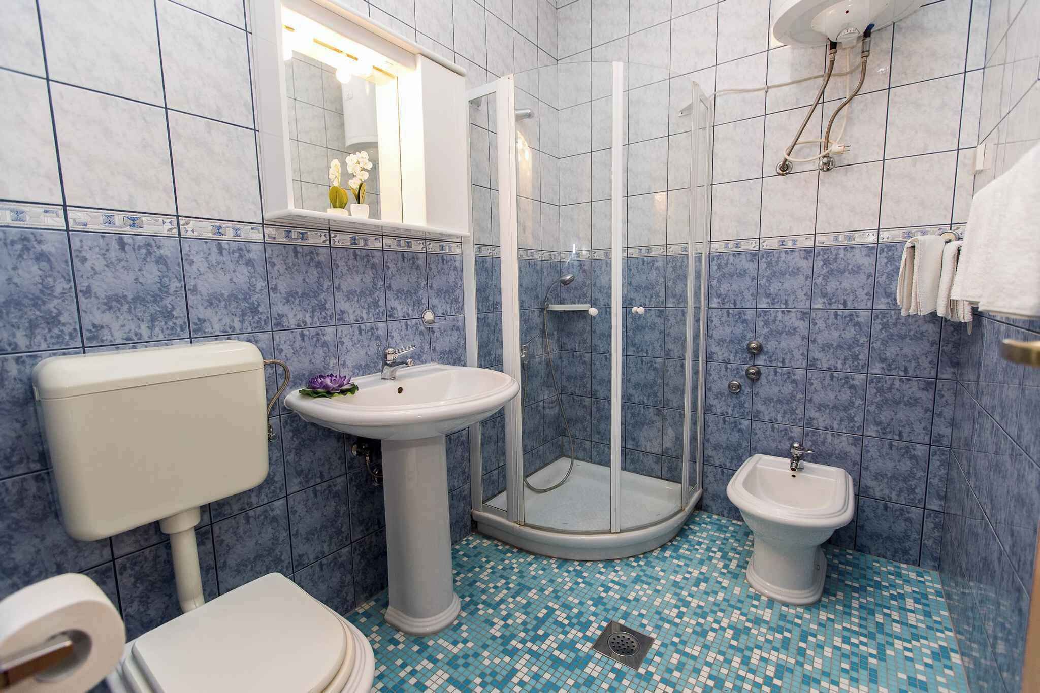 Une salle de bain comprenant des toilettes, un lavabo sur colonne et un bidet.