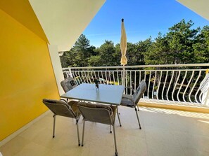Enjoy a peaceful moment on the balcony with a view of the surrounding trees and sky.