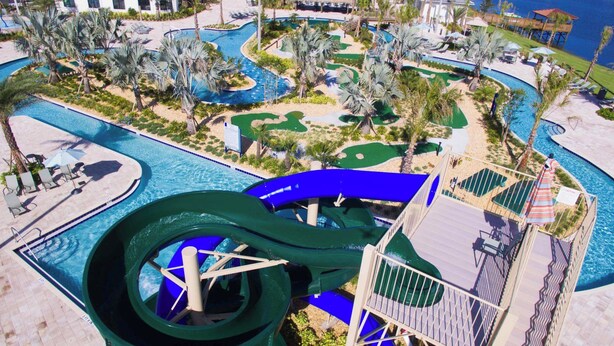 Een groot waterpark met meerdere zwembaden en een glijbaan.