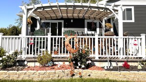 A house with a covered porch, white railings, and a small garden area with decorative elements. - Modern  • Attached garage • Dog friendly • ATV & Sled friendly (Ironwood)